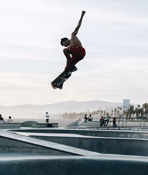 Skateboarder performing a high jump at a skate park.